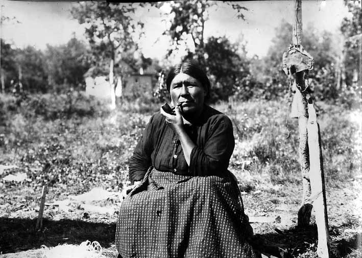 Cree woman smoking her pipe at