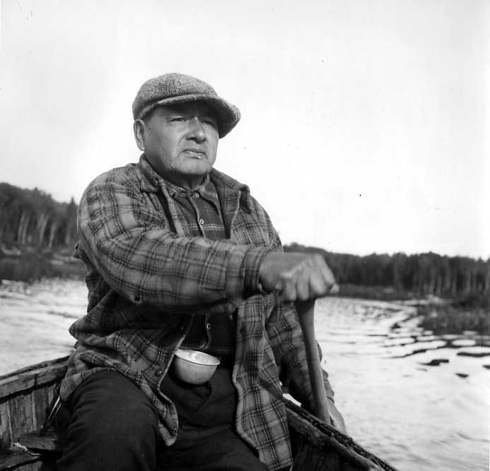Ojibwa man paddling in his canoe.
Original caption: