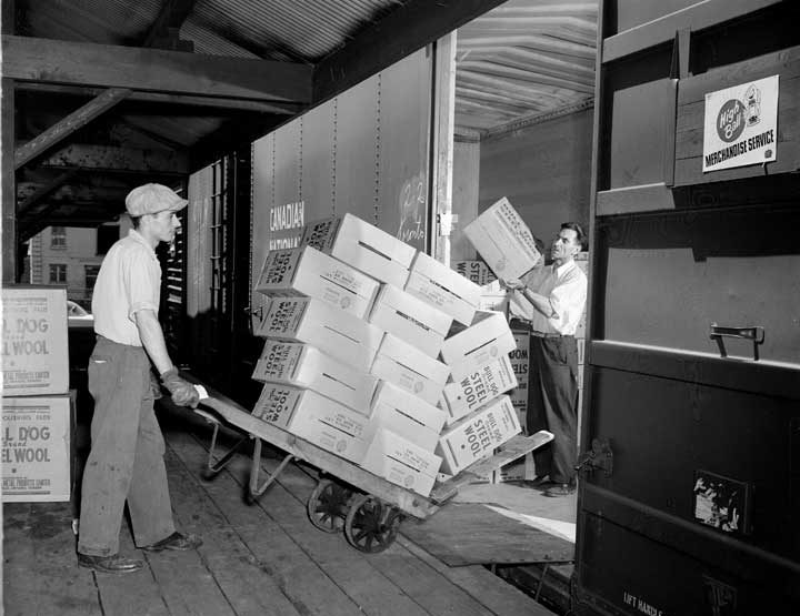 Loading crates of steel wool onto a box car