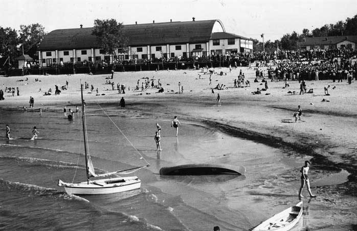 Visitors sunbathing and swimming at Grand Beach