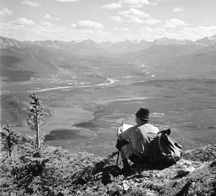 A hiker contemplating the view of the valley from Pyramid Mountain at Timberline