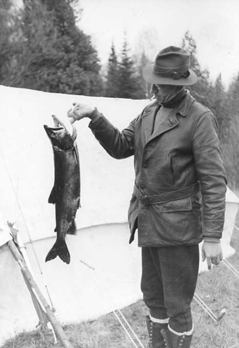 Fisherman with his catch, a grey trout caught in Burnt Lake
