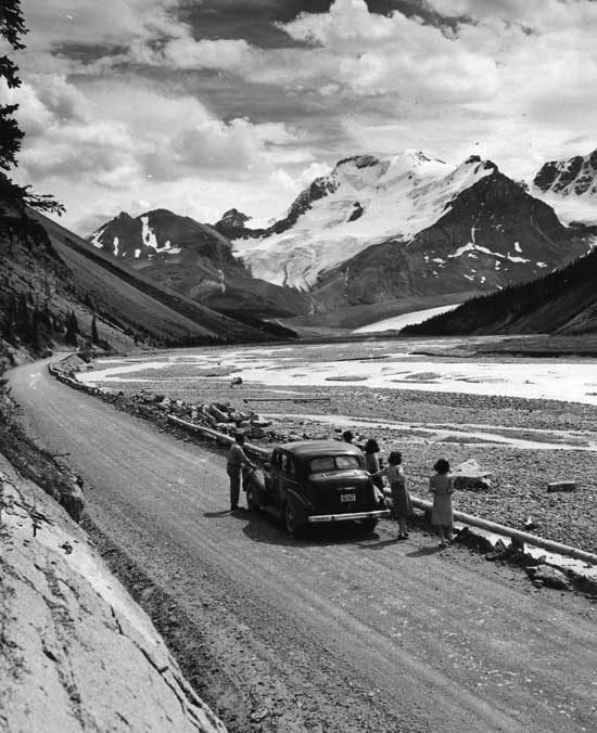 Tourists pausing on the Columbia Icefield Drive to look at Mount Athabasca