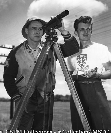 Surveying crew, Cy Biegler and Ben Nyeste, working in advance of repair gang to stake the line giving the necessary amount of rise needed to keep a constant level on the track