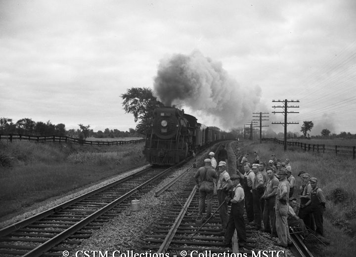 The replacement gang enjoys a breather while a freight train rumbles by; they carried out rail replacement without delaying any operating train