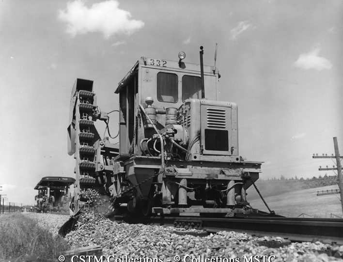 Ballast distributor, a self-propelled machine which picks up ballast from both sides of track and puts it back down evenly on either side of the rails