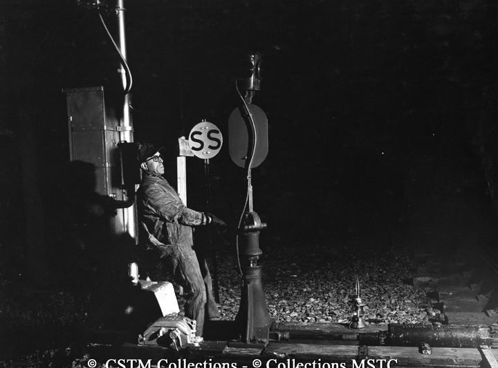 Brakeman J.A. Laferrière turning the switch to allow freight “495” to move in the siding to pick up cars destined for Toronto