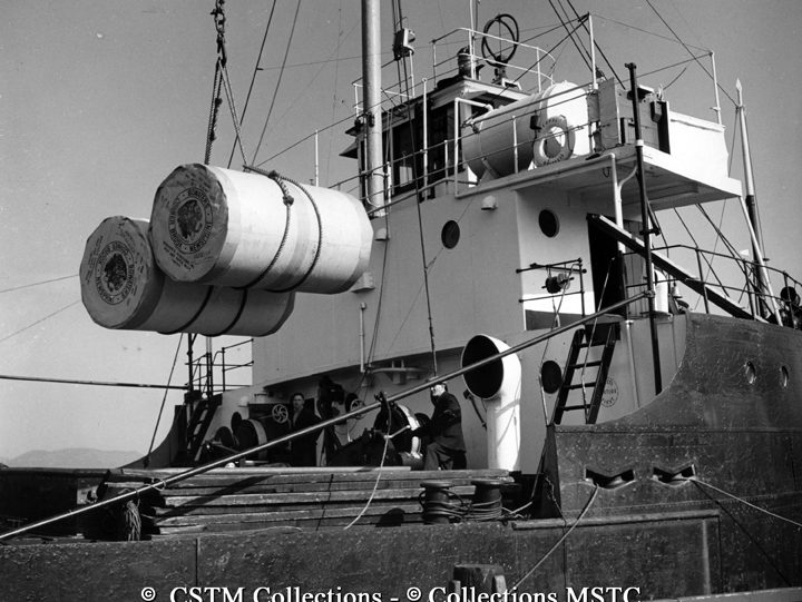 Rolls of newsprint are loaded on board the S.S. Trenora from the dock of Bowater’s Newfoundland Pulp and Paper Mills Limited