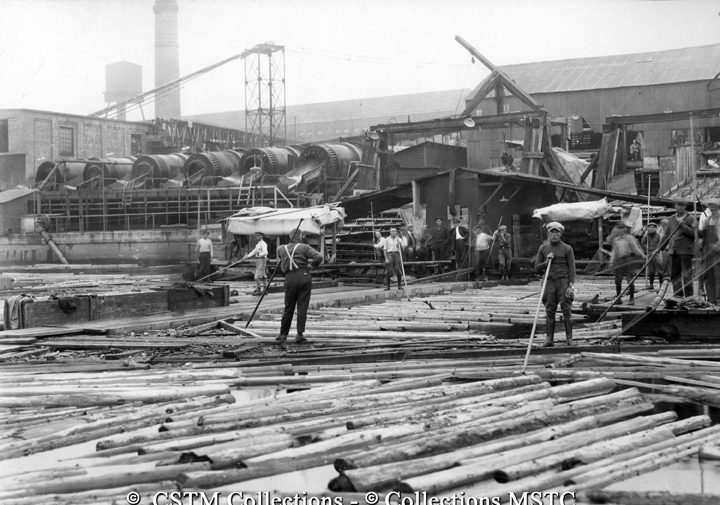 Employees of the Laurentide Pulp Mill directing logs into the mill