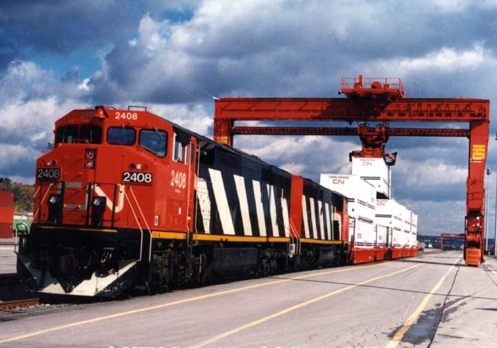 General Electric diesel locomotive Dash 8-40 CM 2408 with Five-Pak cars at the Montreal container terminal.  The locomotive is built with the Draper Taper and ditch lights