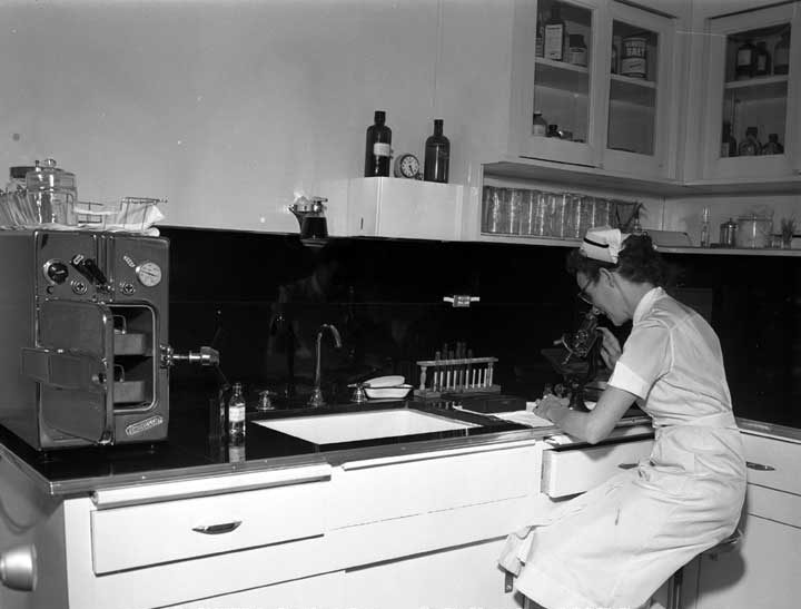 Nurse looking through a microscope in one of the laboratories of a new Toronto medical clinic