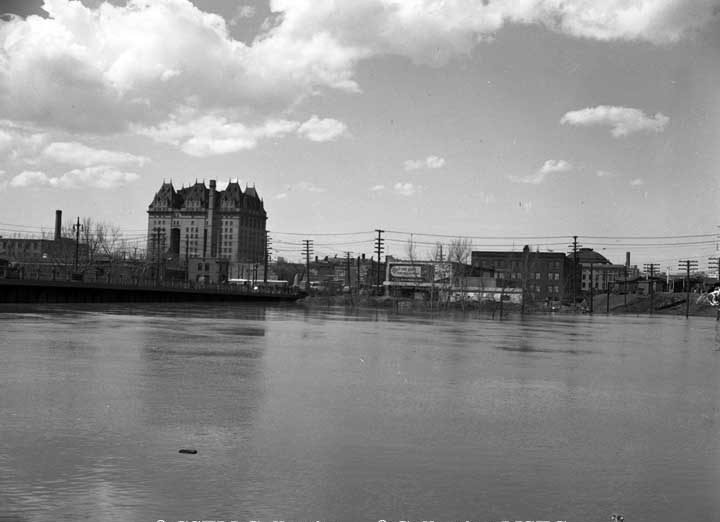 A view of the Red River, with the back of the Canadian National Station in the foreground and the Fort Garry Hotel on the left