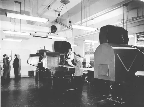 A trainee in a Link trainer receiving instructions