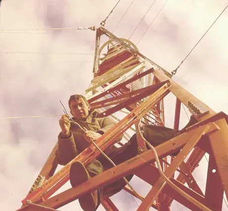 Engineer checks wiring on microwave radio tower