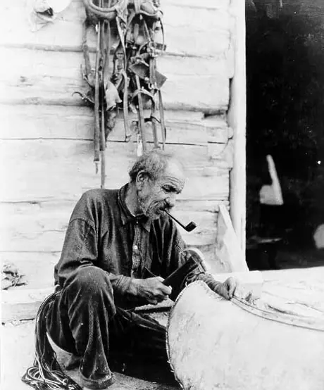 Louis LaVallee repairing birch bark canoe