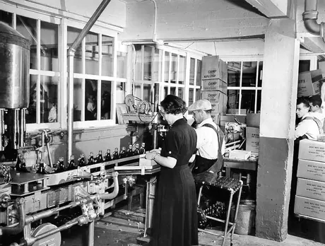 Using a bottling line to bottle maple syrup at a Camp Maple Syrup factory