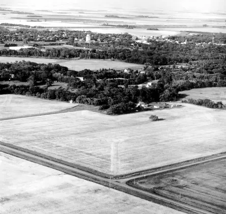 An aerial view of a combine harvesting wheat fields