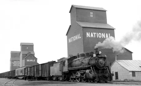 Freight train passing grain elevators