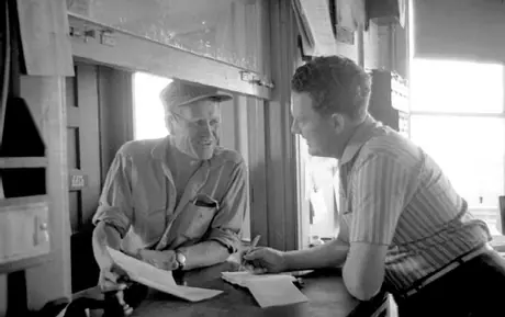 Grain elevator operator informing a farmer of the grade of his grain and its value