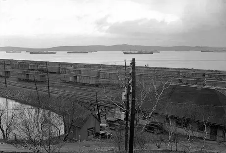 View of munitions ships waiting for convoy by a rail yard at Bedford Basin