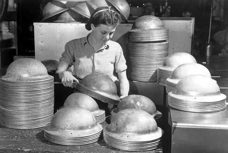 Woman worker making steel soldiers' helmets at General Steel Wares