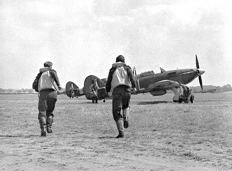 RCAF crew run toward their fighter aircraft as ground crew stand ready to help them into parachutes