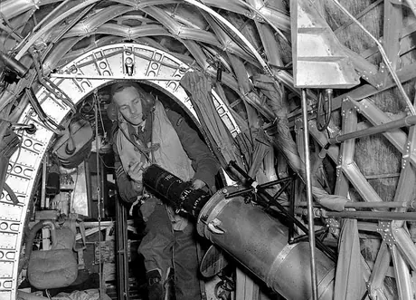 An RCAF bomber crew member releasing a flare to light up a target for other bombers or photography