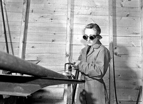 A member of the RCAF Women's Division does welding work on an aircraft
