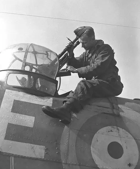 An armourer for the RCAF's Blenheim Fighter Squadron fits guns into the rear turret of his aircraft