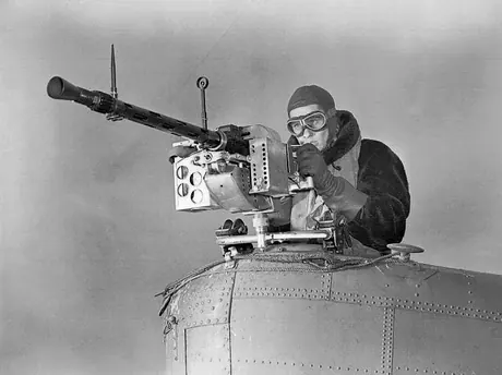An RCAF air gunner checks over the gun of a Stranraer flying boat