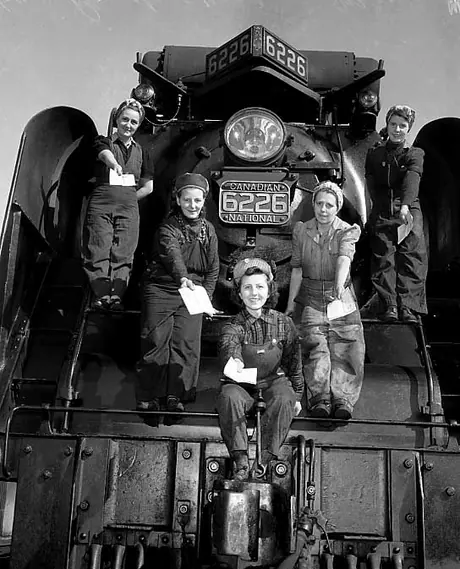 Five sisters employed in the Mimico Roundhouse of the CNR show their war bonds while standing in a