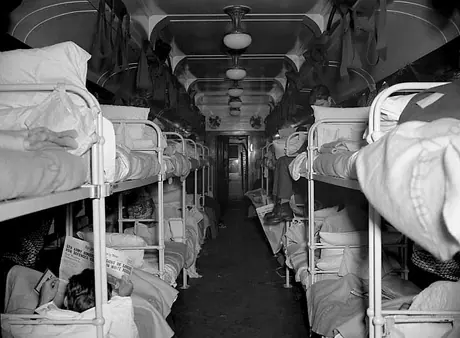 Injured soldiers rest and read newspapers in their bunks on a hospital train