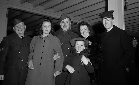 Private Johnstone Montgomery (centre) has been sent home due to injury and is greeted by his family