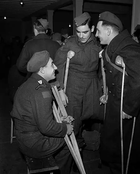 Wounded soldiers Pte. Doucette, Pte. Major, and Pte. Sturnagel talk in the train station