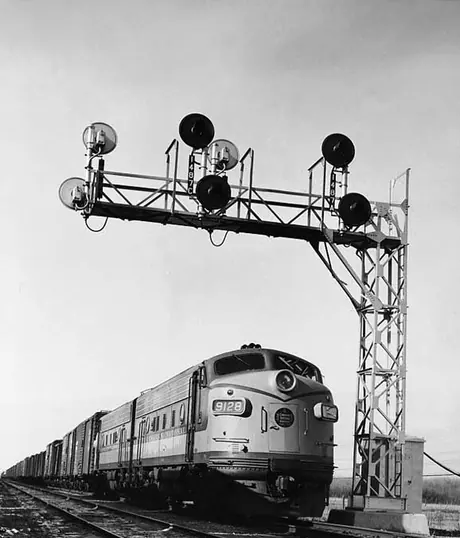 A diesel freight train passing new signals outside Paddington Yards