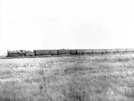 Canadian Northern Railway steam locomotive no. 703 pulls passenger train across prairies