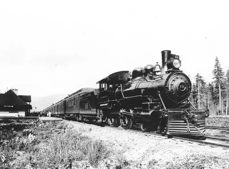 Steam locomotive no. 111 hauls Grand Trunk Pacific Railway passenger train on main line