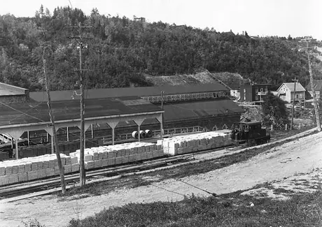 An electric locomotive hauls a paper train at the Chicoutimi Pulp Mill
