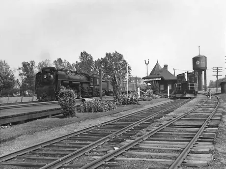 Canadian National Railways steam locomotive no. 6233 and passenger train stop  at railway station at Gananoque Junction opposite diesel locomotive