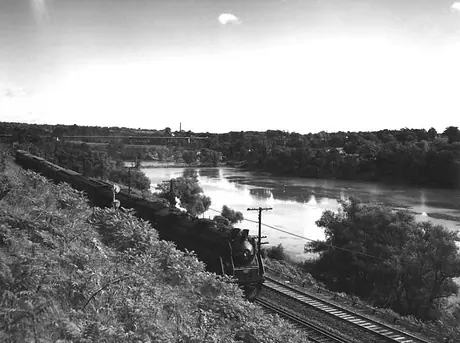 A Canadian National Railways passenger train steams along the river near Hamilton