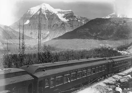 A close-up view of Canadian National Railways passenger cars with Mount Robson in the background