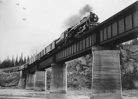 A Canadian National Railways passenger train crosses a bridge over the Solomon River, viewed from below