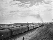 Pullman passenger coaches are hauled across the Canadian prairies by a Canadian National Railways steam locomotive