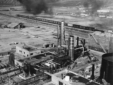 A freight train passes a petroleum products plant