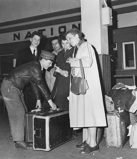Porter assists displaced persons with their luggage