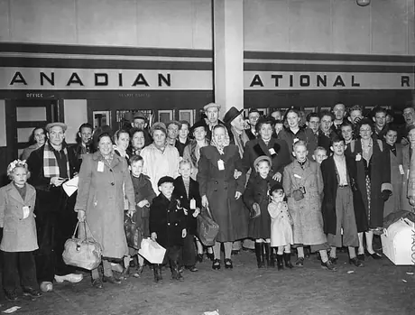 Recent immigrants from Holland gather at a Canadian National Railway station to board their trains