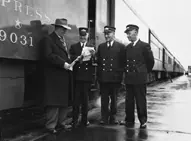 Canadian National Railway employees beside the press car of the Royal Tour Train
