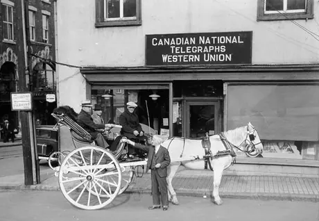 A carriage stops in front of a Canadian National Railway telegraph office