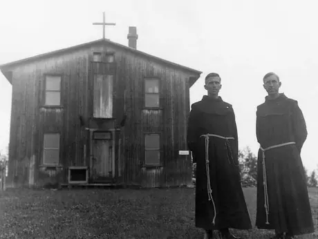 Catholic brothers stand in front of a church building
