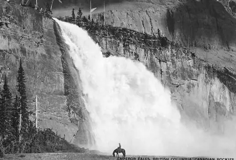 Horse and rider near a waterfall in the Canadian Rockies